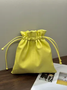Minimalist yellow leather drawstring pouch bag, soft cloud handbag for women daily casual use.