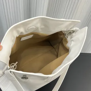Bolsa cubo de cuero suave blanco vista interior, amplio compartimento con herrajes.