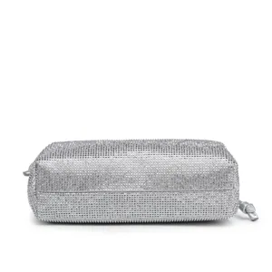 Close-up detail of the sparkling silver rhinestone clutch bag with a neat zipper and knot.