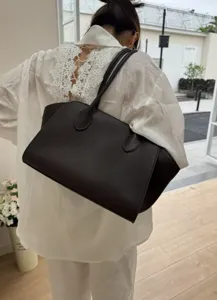 Detailed view of the dark brown leather tote bag showcasing shoulder carry and fine straps.