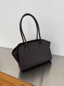 Detailed view of the dark brown leather tote bag showing fine stitching and minimalist structure.
