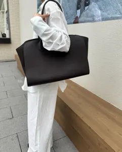 Minimalist cowhide leather tote bag detail, large capacity fashion commuting shoulder handbag.