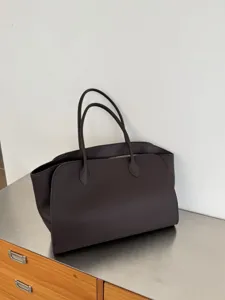 Dark brown leather tote bag detail, premium minimalist shoulder handbag for daily commute style.