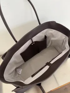 Detailed view of the brown leather tote bag interior, showing chevron lining and pockets.