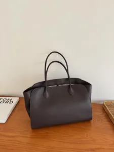 Dark brown leather tote bag detail, minimalist design, premium large capacity handbag style.
