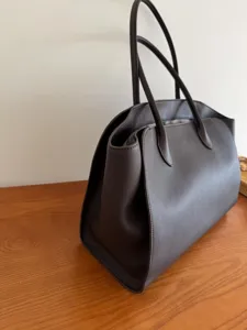 Dark brown leather tote bag detail, minimalist shoulder bag for women daily commute style.