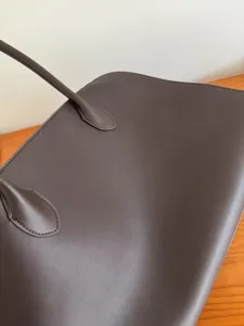 Detail view of premium dark brown leather tote bag, elegant shoulder bag for daily commuting.