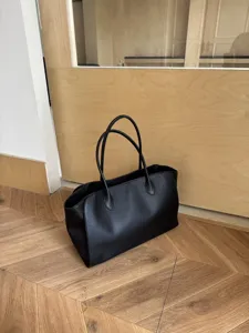 Minimalist black leather tote bag for women, large capacity daily shoulder bag style.