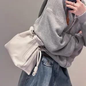 Elegante bolso saco de piel de vacuno suave con diseño moderno y detalle de nudo chic.