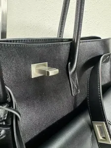 Black leather tote bag with metal lock detail, premium structured handbag for women and men.