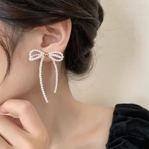 Detaillierte Nahaufnahme von eleganten Perlen Schleife Ohrringen mit langen Quasten Ketten.