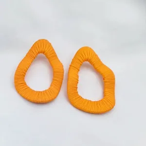 Oranger Stoff umwickelter unregelmässiger Ohrring Detailaufnahme, schick minimalistischer Schmuck
