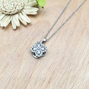 Nahaufnahme der rotierenden Kleeblatt Zirkonia Anhänger Halskette mit feinen Mikro-Pavé-Details.
