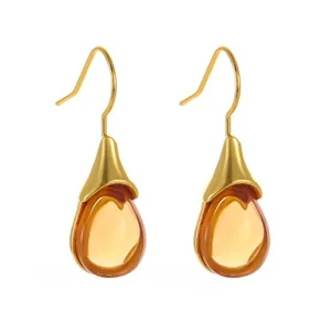 Stunning gold-tone hook earrings featuring elegant teardrop amber-colored stone pendants.