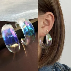 Detailed close-up of translucent iridescent resin hoop earrings with gorgeous light reflection.