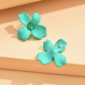 Detailed close-up shot of mint green flower stud earrings with sparkling green crystal center.