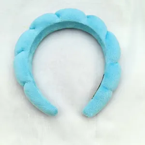 Close-up of fluffy blue cloud headband, soft velvet material, ideal for daily makeup and face washing.
