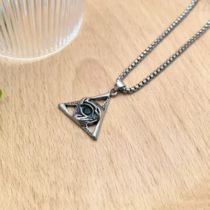 Metal triangle eye pendant necklace detail shot, vintage punk style jewelry accessory for daily wear.