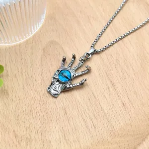 Gothic demon hand blue glass eye pendant necklace detail view, retro silver metal finish.