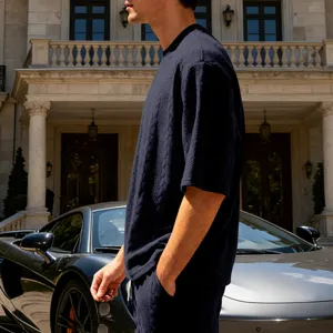 Close-up detail of dark blue cable-knit short sleeve t-shirt showing textured fabric.