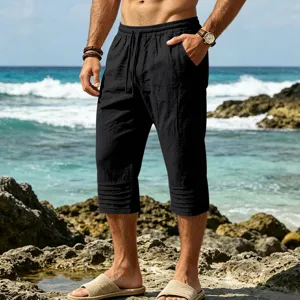 Detail view of men black capri shorts featuring pleated cuffs and casual drawstring waist.