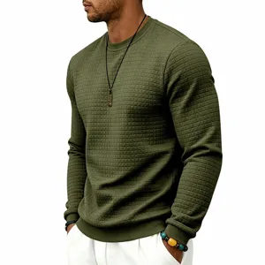 Close-up detail of the textured waffle grid fabric and ribbed crewneck collar on green sweater.