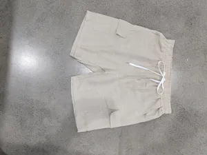 Pantalones cortos cargo de playa para hombre casuales y holgados, detalle en beige.