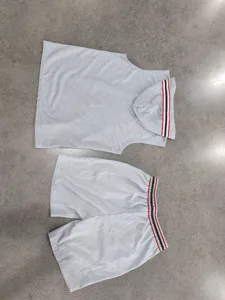 Detail view of grey sleeveless hooded vest and shorts sportswear set with striped rib trim.