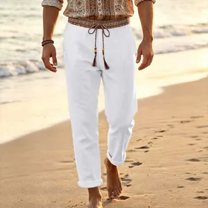 Men white casual linen beach pants with ethnic drawstring belt detail in coastal scene
