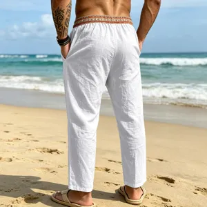 Detailed back view of white linen beach trousers featuring an ethnic patterned waistband.