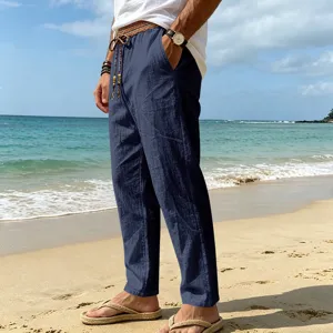 Detailed view of men's loose linen casual beach pants in dark blue with tribal drawstring.