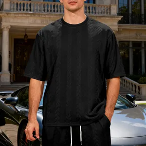Black textured knit short sleeve t-shirt detail showing premium fabric and relaxed fit.