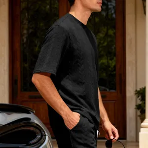 Detailed shot of men's black textured knit short sleeve shirt showcasing fine craftsmanship.