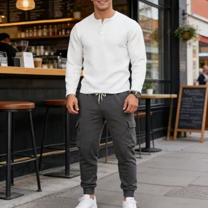 Detailed view of men's casual waffle henley shirt and cargo sweatpants set in street scene.
