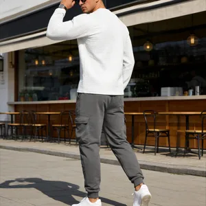 Men casual waffle long sleeve top and grey cargo pants set, outdoor street fashion detail view.