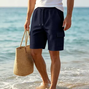 Detail view of men's waffle cargo shorts in navy blue with pockets for beach and vacation.