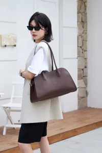 Classic East-West leather tote bag in dark brown with pebbled texture and long handles.