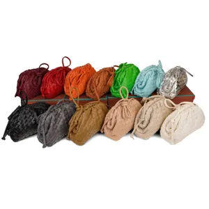 Detailed view showcasing multiple colors of woven leather cloud shoulder bags with knot handle.