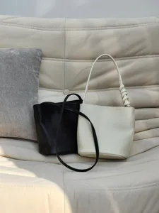 Sac seau minimaliste en peau de mouton au tannage végétal, sac porté épaule chic et décontracté.