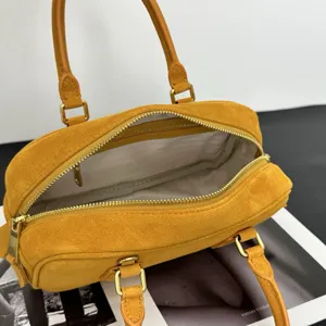 Detailansicht der eleganten gelben Wildleder Bowling Handtasche mit Reissverschluss.