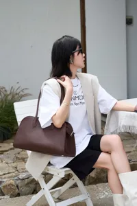 Brown litchi pattern cowhide long handle shoulder tote bag, high-end fashion design.