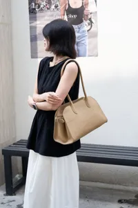 Detail view of khaki leather EW tote bag, soft pebble grain texture, elegant shoulder strap