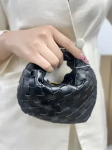 Detailed shot of black woven leather handbag, premium handmade intrecciato design.