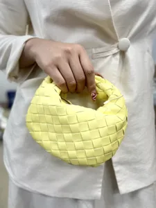 Detailed close-up view of the vibrant yellow woven leather bag handle and craftsmanship details.