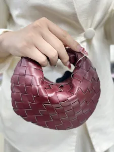 Close-up of wine red woven leather handbag showcasing premium handcrafted texture detail.