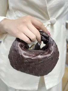 Detail shot of the dark brown woven leather handbag showing exquisite craftsmanship and texture.