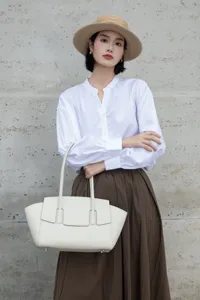 Elegant white leather tote bag with unique double handles, stylish and functional design.