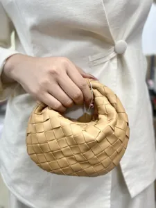 Detailed view of woven leather handbag detail, classic intrecciato design and texture.