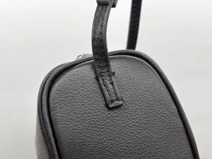 Minimalist dark brown leather shoulder bag detail, premium top-layer cowhide handbag.
