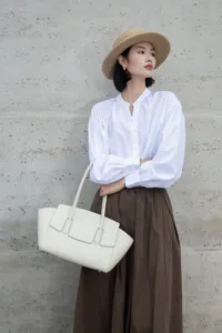 Elegant white leather tote bag detailed view, minimalist chic design with stylish front loops.